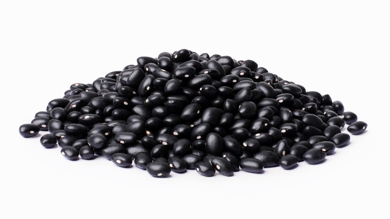 A pile of black beans isolated against a white background