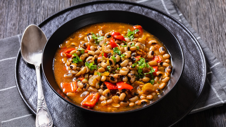 A bowl of Hoppin' John is garnished with green leaves.