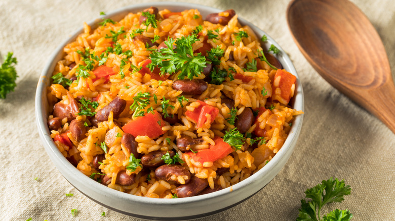 A bowl of red beans and rice is garnished with parsley.