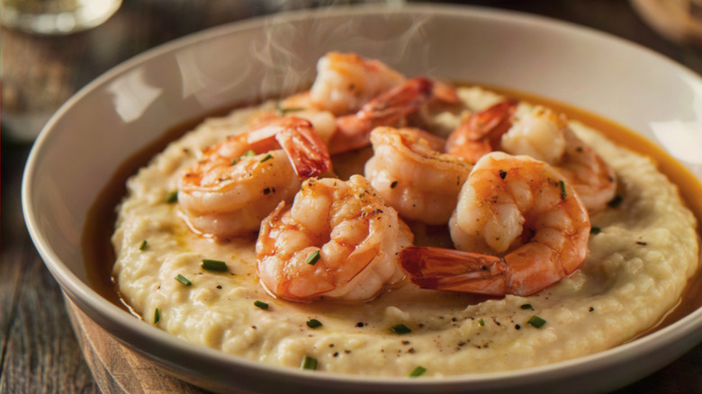 A steaming bowl of shrimp and grits is shot up close on a table.