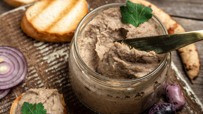 Vegetarian pâté in a glass jar with a butter knife
