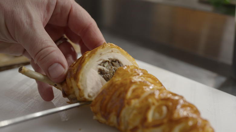 Hand prepares meal in Chef's Table: Legends