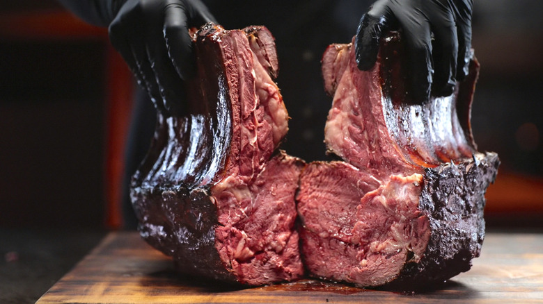 Hands hold barbecued meat in The American Barbecue Showdown