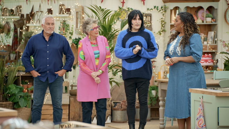 The hosts of Great British Bake Off stand and talk