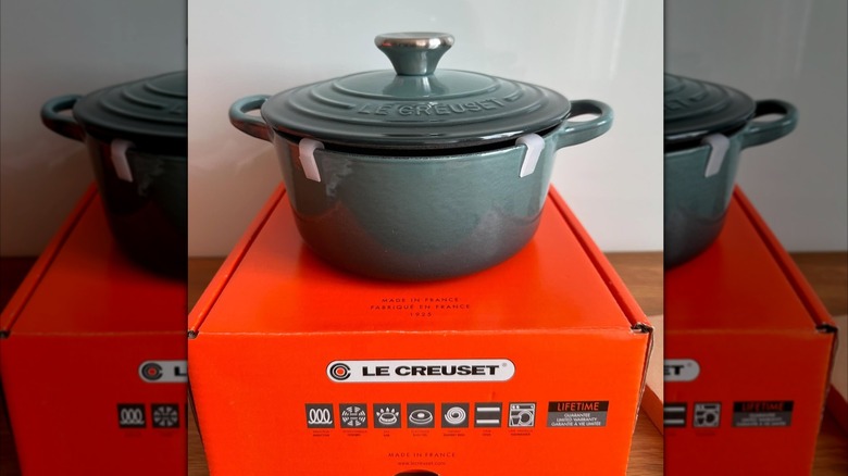 A new blue Le Creuset Dutch oven sits on top of its box