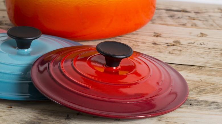 A pair of Le Crueset lids, both with black plastic hands