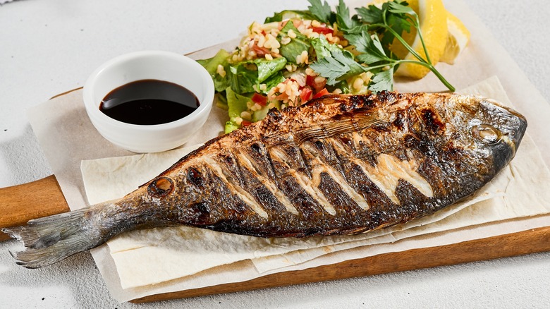 grilled fish on wooden board