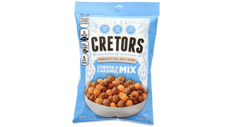 Cretors Cheese and Caramel Popcorn Mix from Dollar Tree in a pale blue bag against a white background.