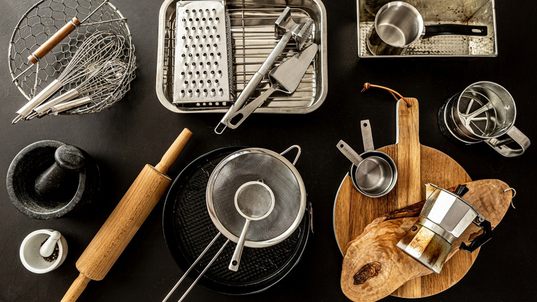 An assortment of kitchen tools arranged on a black countertop