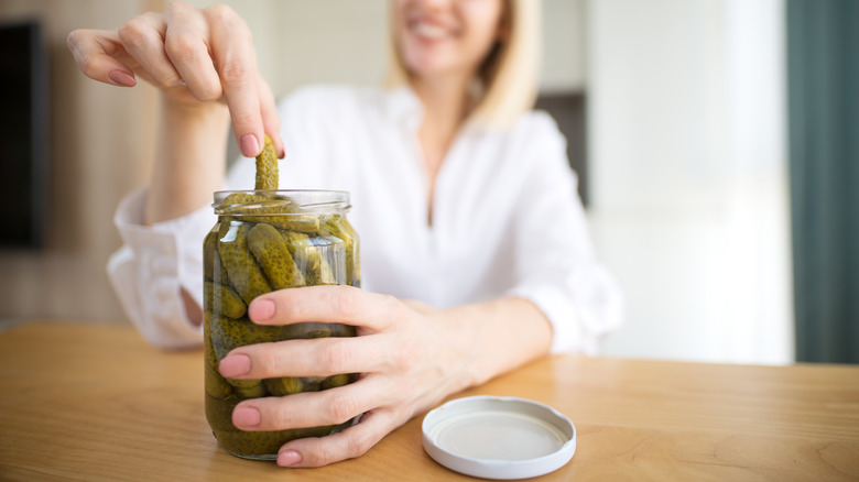 woman grabbing pickle