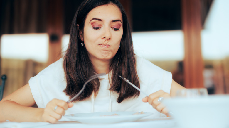 woman looking skeptically at plate
