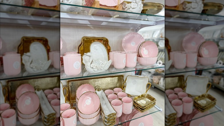 HomeGoods shelves full of gold-rimmed pink and white dishes.