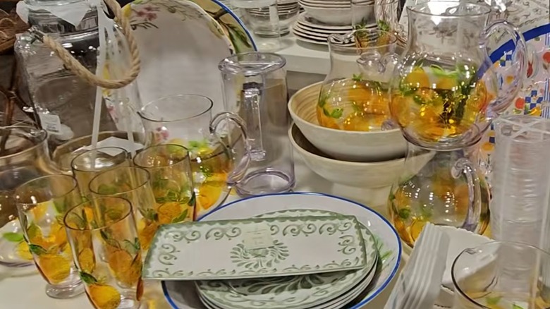 Glass pitchers and tumblers with lemon pattern on HomeGoods shelf.