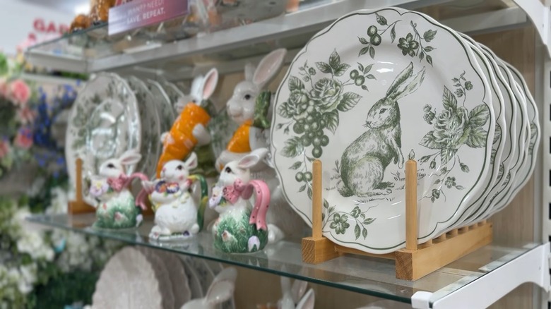 Round plates featuring rabbit and flower designs next to rabbit figurines on HomeGoods shelf.