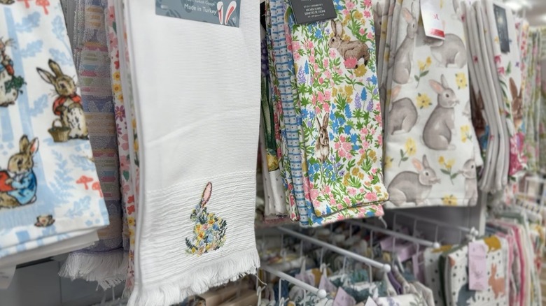 Wall of hanging dish towels with rabbits, flowers, and bright colors in HomeGoods.