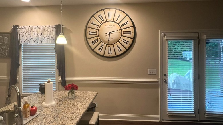 A giant clock on a kitchen wall
