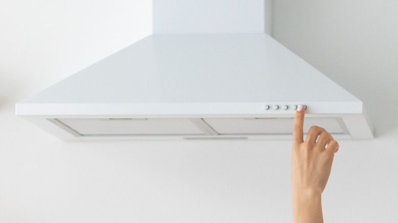 Person turning on range hood