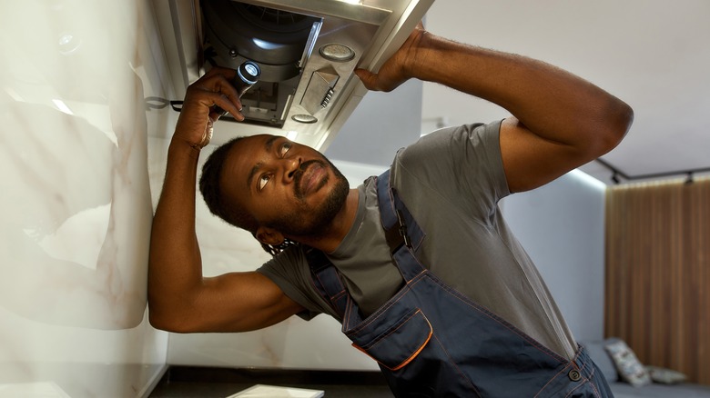 Repairman maintaining a range hood