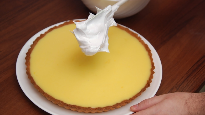 Putting meringue on lemon pie