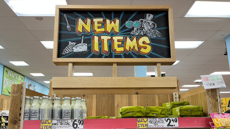 A painted chalkboard sign at Trader Joe's advertises new items.