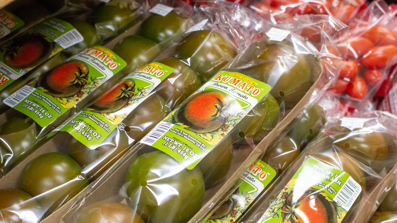 A image of kumatoes and cherry tomatoes in plastic packaging at Trader Joe's.
