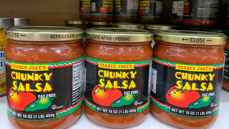 A row of Trader Jose's chunky salsa jars sit on the shelf at a store.