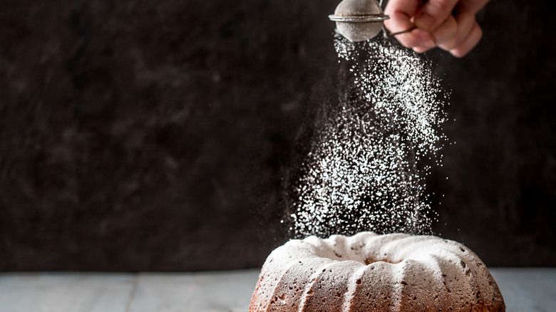 sprinkling powdered sugar on cake