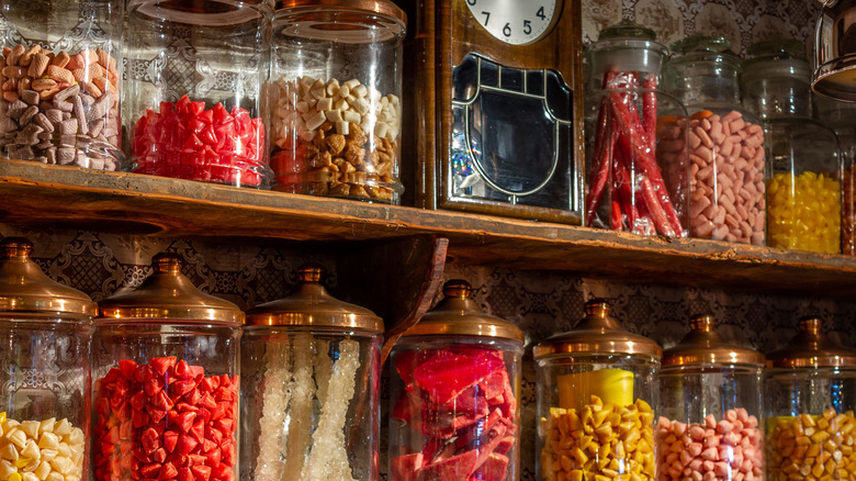 Jars of colorful candy on a wooden shelf in an old-fashioned candy store