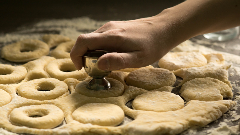Person cutting donuts with tool
