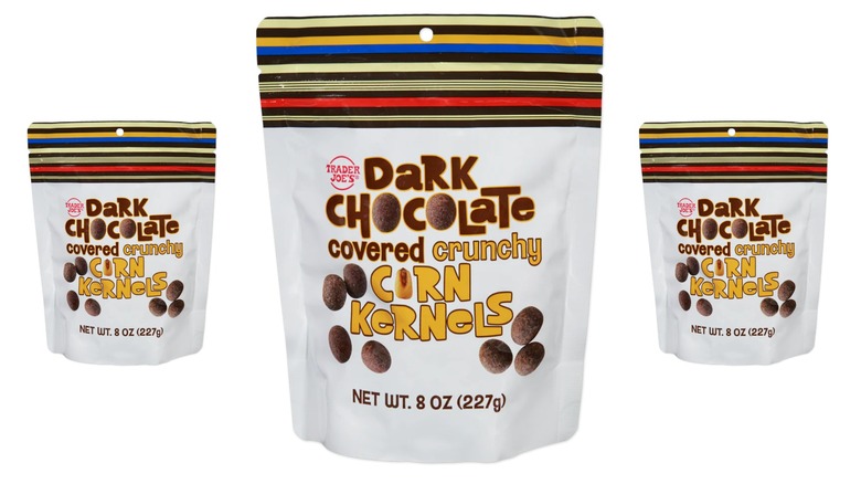 3 bags of Trader Joe's Dark Chocolate Covered Crunchy Corn Kernels with a white bag and striped top against a white background.
