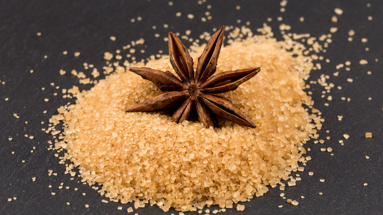 Whole star anise sitting in a pile of brown sugar