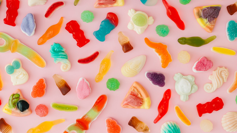 A selection of gummy candy pieces on pink background