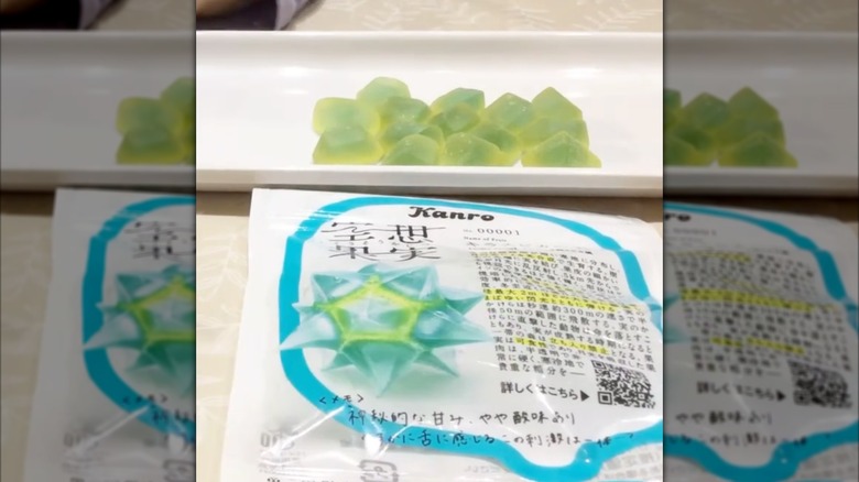 package of Kanro Kiraspika gummies next to plate of green gummies