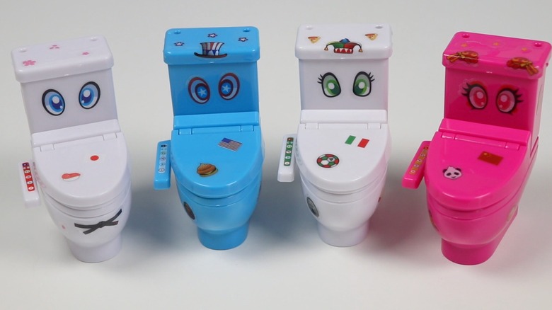 Moko Moko Mokoletto Toilet Foam Candy, row of four plastic toy toilets with stickers