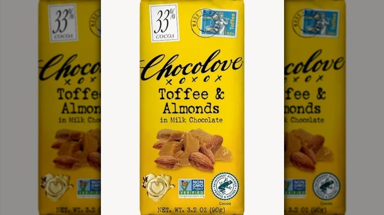 Chocolove toffee and almonds bar in a yellow wrapper on white background