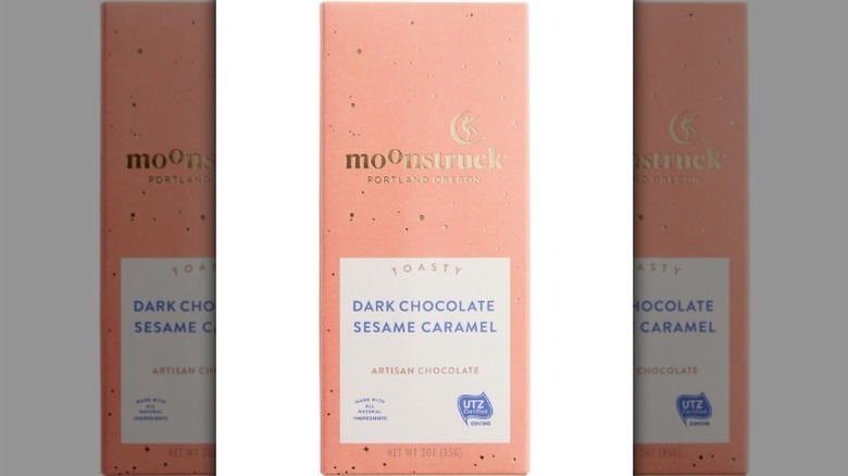 Moonstruck dark chocolate sesame caramel bar in a pale pink wrapper on white background