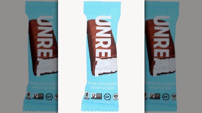 Unreal dark chocolate coconut bar in a light blue wrapper on white background