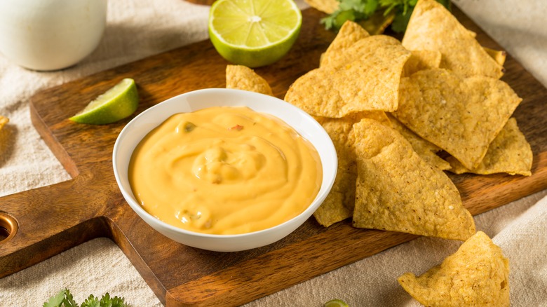 queso dip with chips and lime