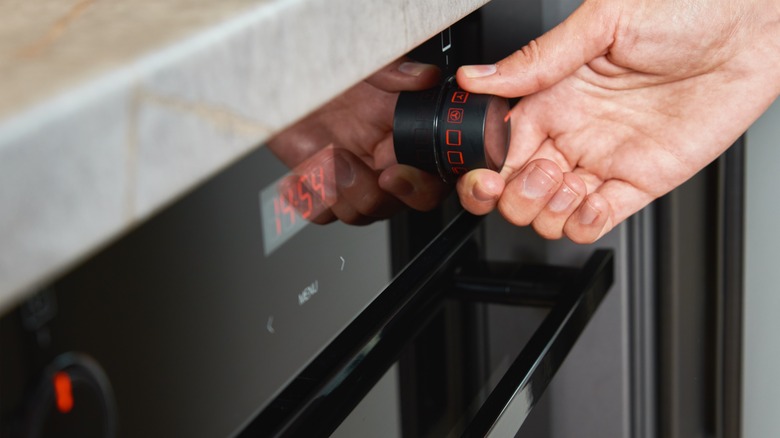Person adjusting oven settings