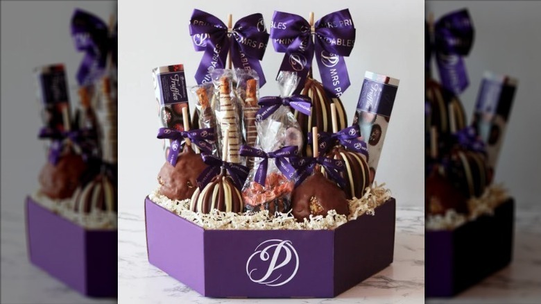 Gourmet caramel apples and confections box on white counter