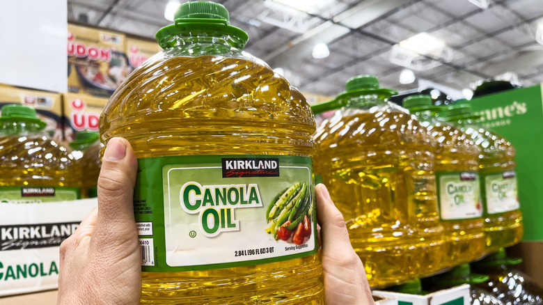 Hands holding bottle of Kirkland Signature Canola Oil