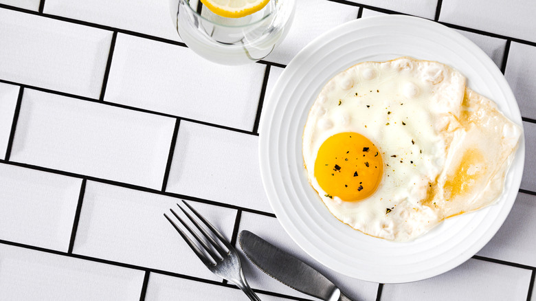 Fried egg on plate, with knife and fork