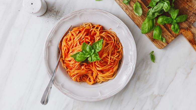 Plate of pasta with tomato sauce, with fresh basil
