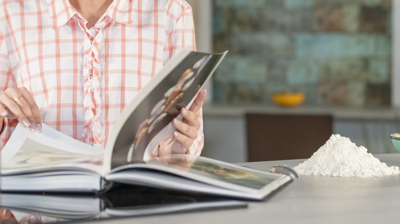Person flicking through cookbook pages