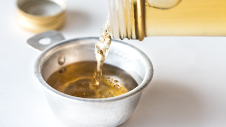 White wine vinegar pouring into cup