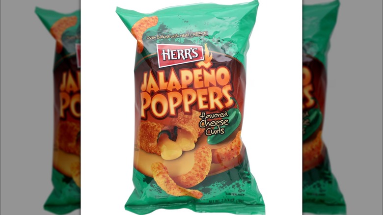 A green and orange bag of Herr's Jalapeño Popper Cheese Curls against a white background.
