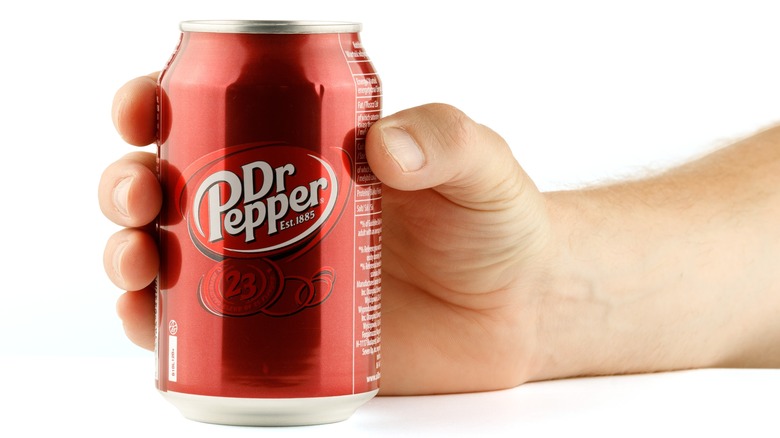 Hand holding a can of Dr Pepper