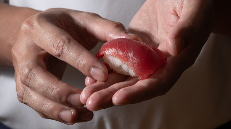 Chef holding a piece of sushi