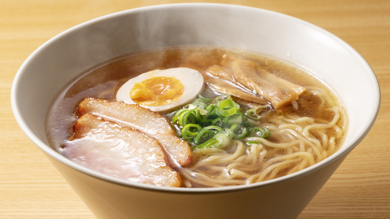Bowl of ramen noodles, with pork, spring onions, and a halved egg