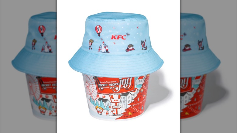 A KFC holiday bucket hat sat atop a holiday-decorated KFC chicken bucket